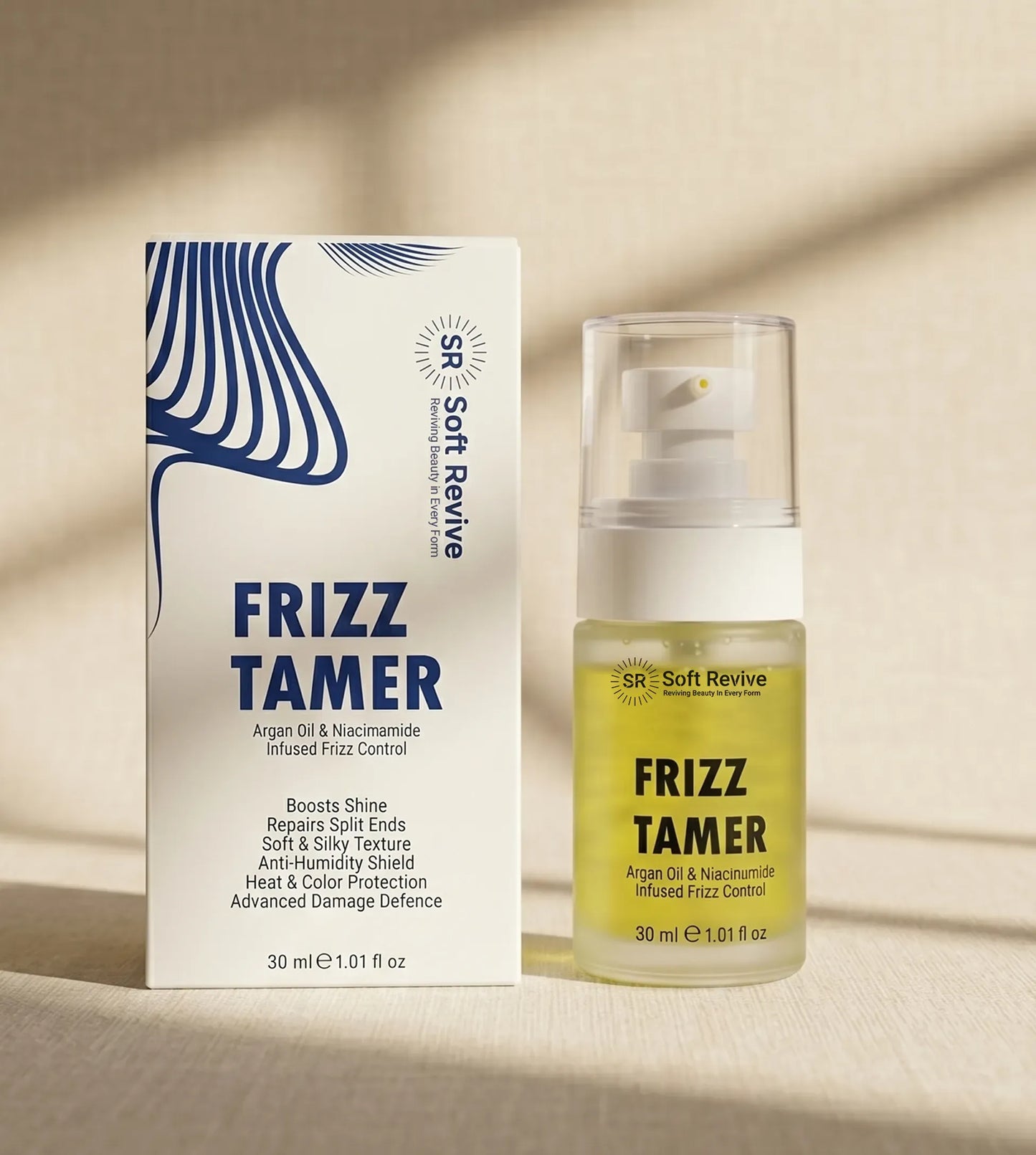 Soft Revive Frizz Tamer hair product shown with its white and blue retail box next to the clear bottle containing pale yellow oil, on a warm beige surface with soft shadows.