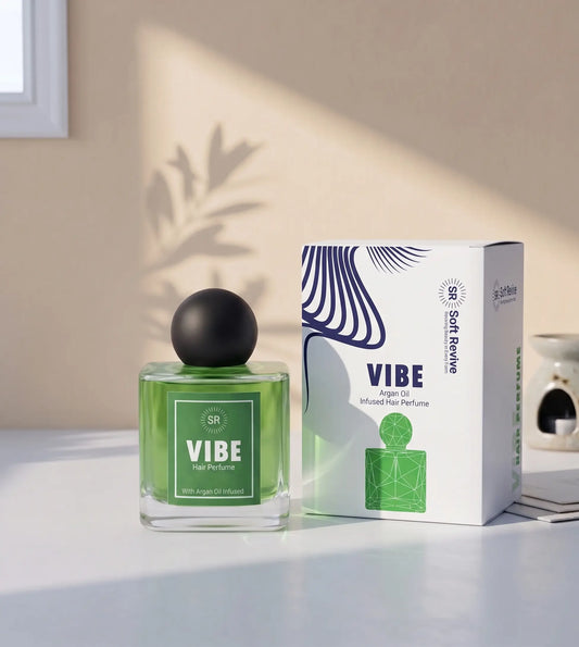 A green glass perfume bottle with a black spherical cap stands beside its white box packaging on a tabletop. The box is labeled 'VIBE' and 'Soft Revolve' with abstract blue line art.